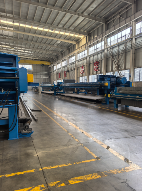 郑州朴华科技现代化的环保设备生产基地内部，展示加工设备和组装中的大型压滤机